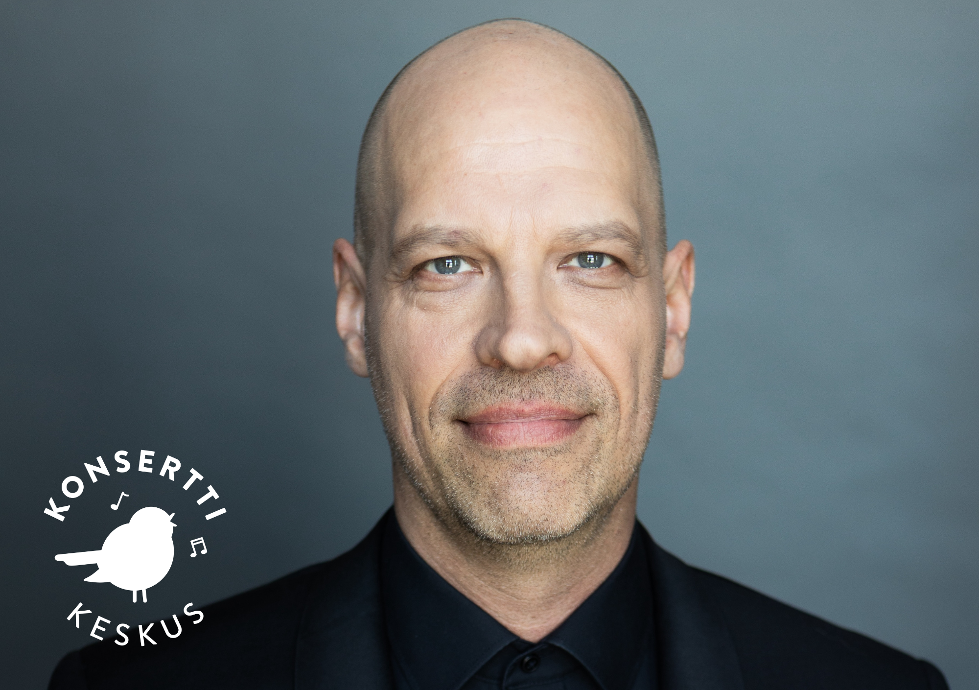 Jussi Chydenius katsoo hymyillen kameraan tummassa puvussa